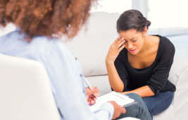 therapist taking notes while consulting a depressed woman